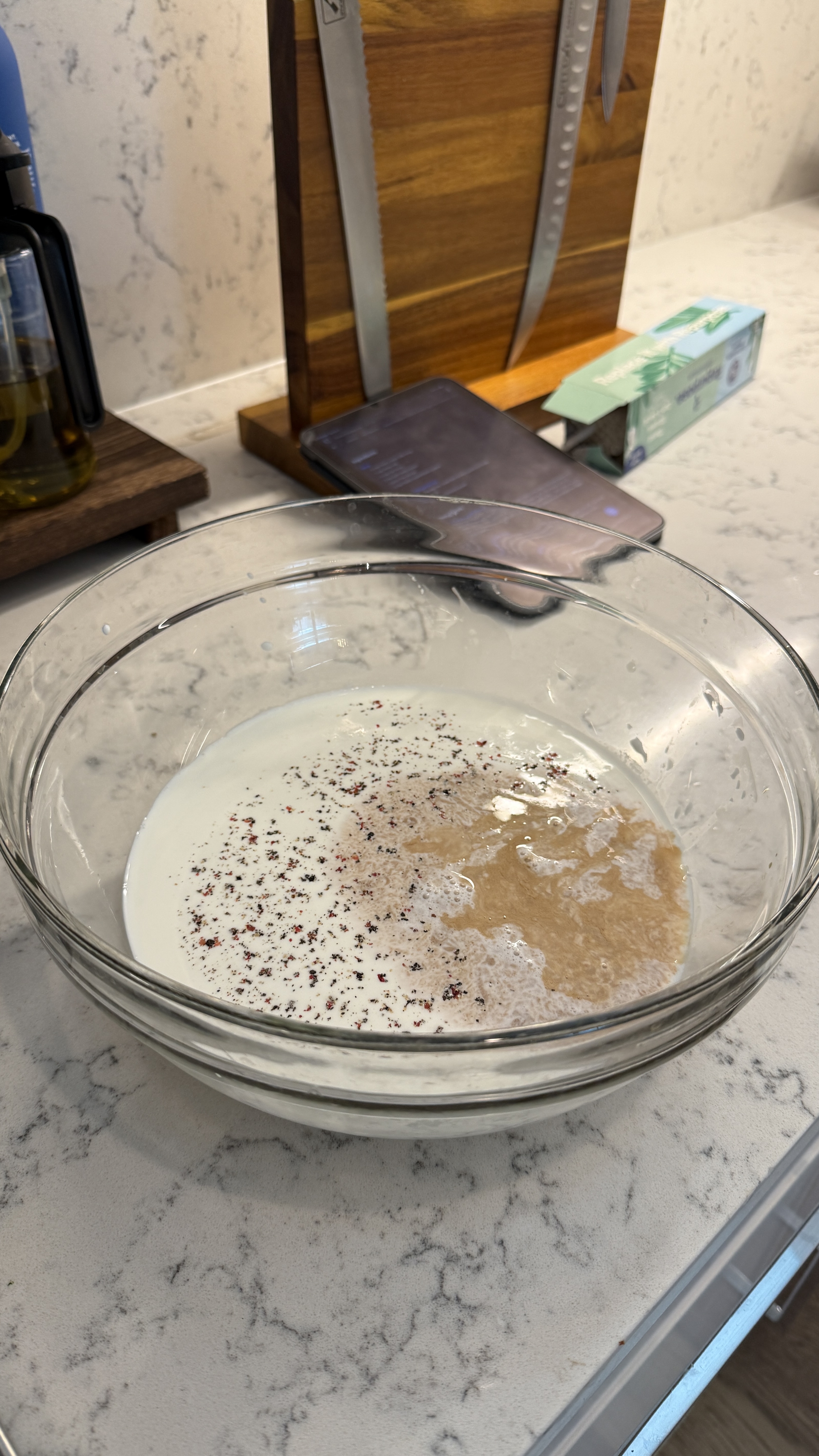 Glass bowl with milk, cracked pepper, and a pool of honey